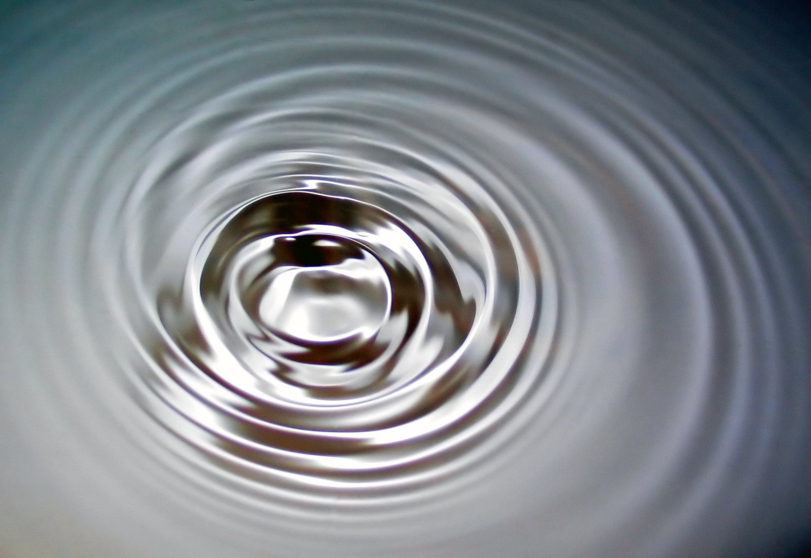 Surface d'eau calme traversée par une onde circulaire